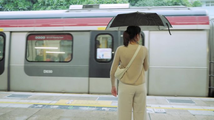 乘坐通勤火车旅行。一名女子在等火车时用手机打电话。