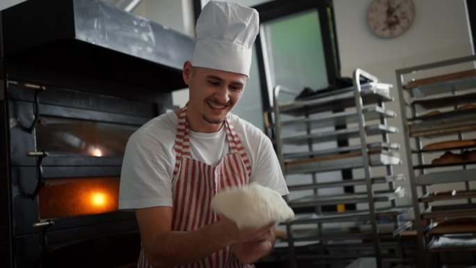 患有唐氏综合症的年轻面包师在面包店准备糕点。残疾人融入社会的概念。
