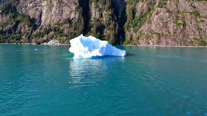 冰山漂浮在水面上。在阳光明媚的日子里，美丽的山海和绿松石般的海水。全球变暖。气候变化。随着全球气候变