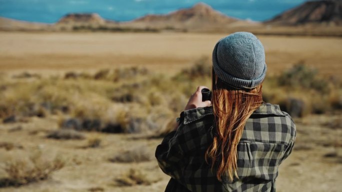 在摩洛哥的沙漠中，一名妇女用双筒望远镜寻找方向