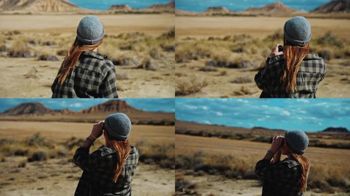 在摩洛哥的沙漠中，一名妇女用双筒望远镜寻找方向