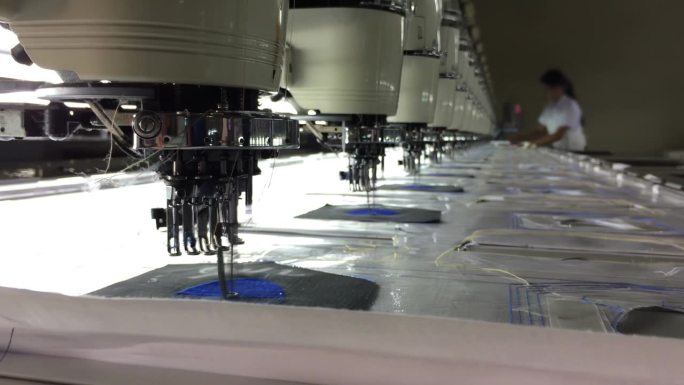 在自动化工厂里裁剪蓝色布料的缝纫机
