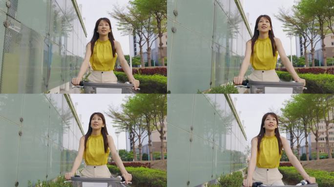 一位亚洲妇女骑着自行车穿梭在城市中。