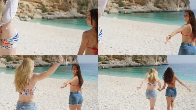 两个迷人的年轻女子跑向大海在热带海滩暑假兴奋地享受清凉的清澈的蓝色的水游泳穿着牛仔短裤