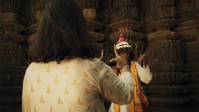 用智能手机拍摄的印度老人穿着传统服装，演奏乐器，诵经的动态肖像。老人保存着丰富的文化遗产