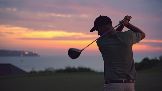高尔夫球场上的运动运动员用球杆打球。热带海岛休闲区运动男性的平静早晨。积极职业人士的现代放松观