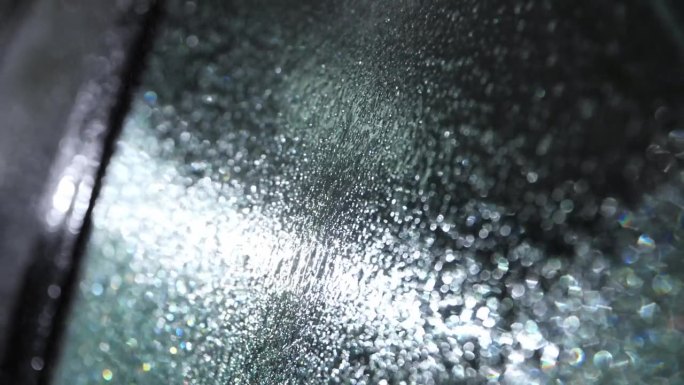 水顺着车窗流下来。洗车时使用高压清洗机。