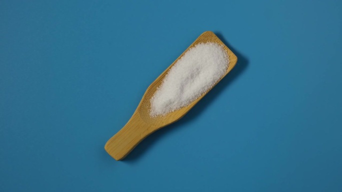 蓝色背景的阿斯巴甜粉末。食品添加剂E951。化学式C14H18N2O5。人造甜味剂，食品和饮料中的糖