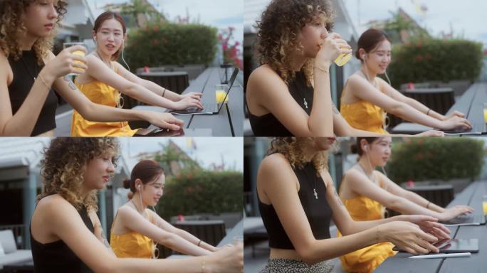 两个美丽的女人在酒吧喝橙汁放松暑假。