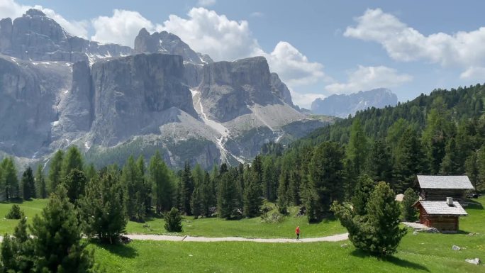 徒步穿越高山景观，欣赏绿色山丘和多石白云石山脉的美景