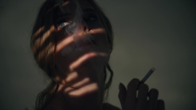 一个优雅的女人在摄影棚里抽烟。
