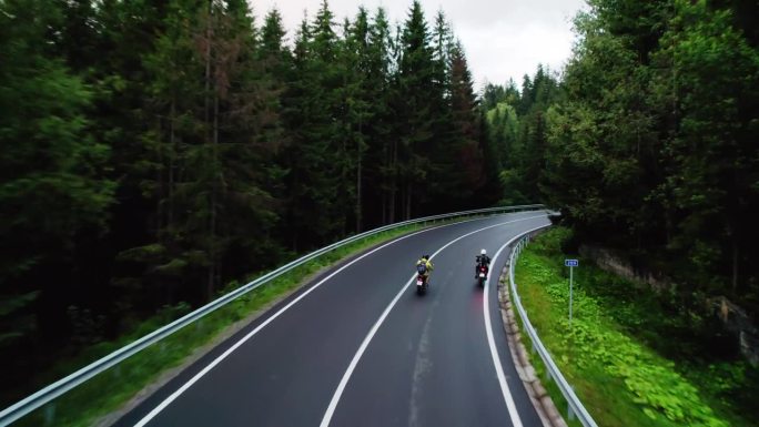 两个摩托车手在一个晴朗的日子里骑在乡间平坦的道路上