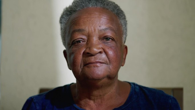 一位巴西黑人老年女性的肖像，表情中性地看着镜头。白发苍苍的老妇人特写脸