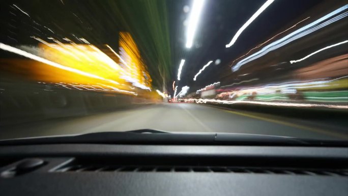 市区高速公路夜间交通的延时拍摄。在一个大城市的夜间快速行驶的延时镜头在停车场结束，汽车的正面视图是有