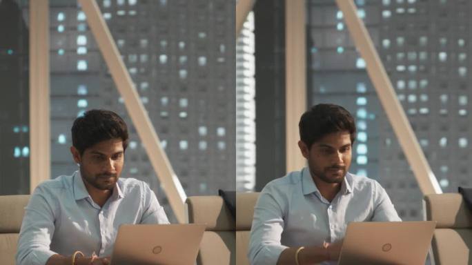垂直屏幕:年轻的印度客户经理在现代公司办公室的笔记本电脑上工作。处理财务报告，为公司准备增长计划