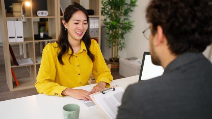 一位男性招聘人员面试一位日裔女性候选人