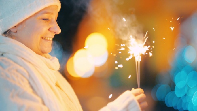 在Čakovec一个充满活力的圣诞主题小巷里，一名欣喜若狂的女子在燃放烟花