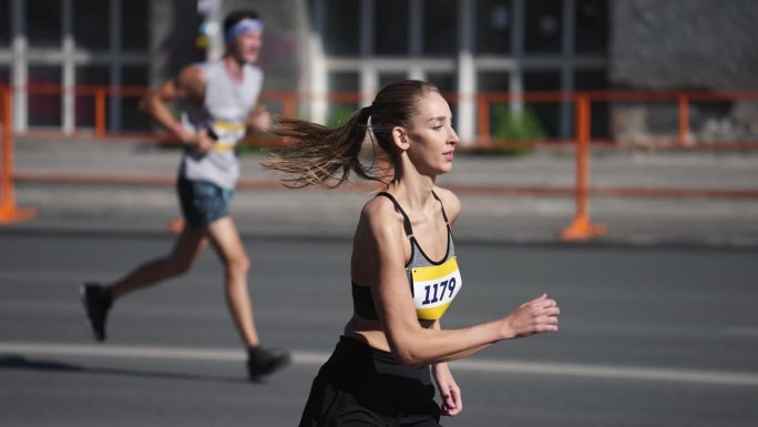 女性慢跑者跑马拉松。女冠军运动员超过了男冠军。女运动员慢跑