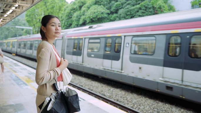 乘坐通勤火车旅行。一名女子在等火车时用手机打电话。