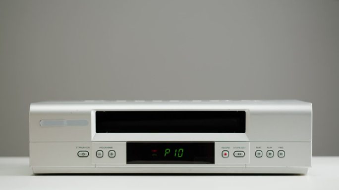 旧录像机的特写，VHS。复古播放器，老式录像带广播在灰色背景，录音带。