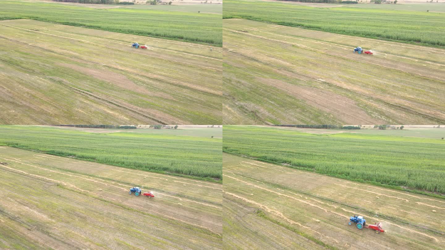 拖拉机打包机机在田野上收集干草