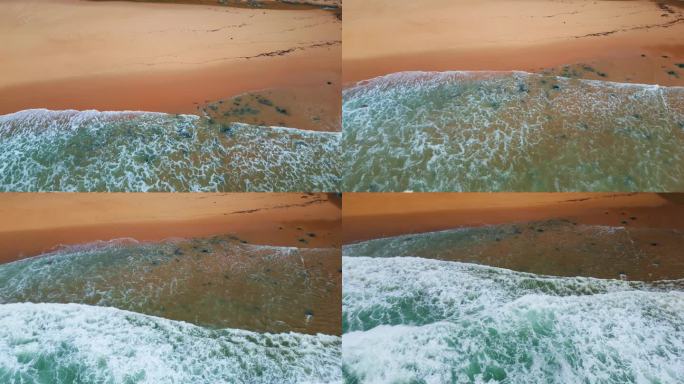 在阴暗的日子里，泡沫的海浪冲刷着沙滩。海浪翻滚的海滩