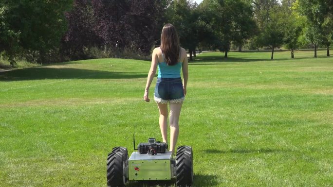 机器人跟着女人美女草地行走只能机器人