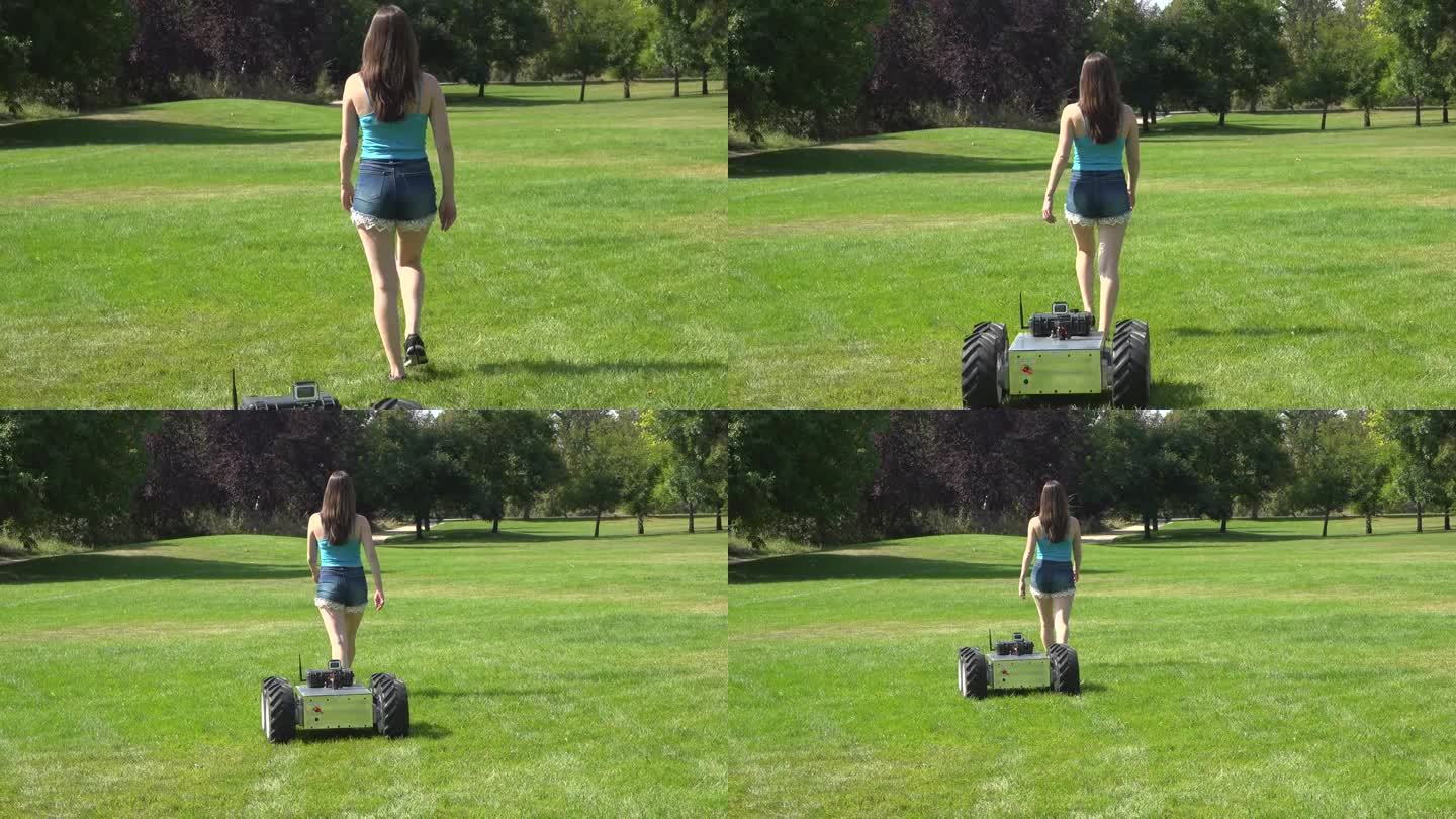 机器人跟着女人美女草地行走只能机器人