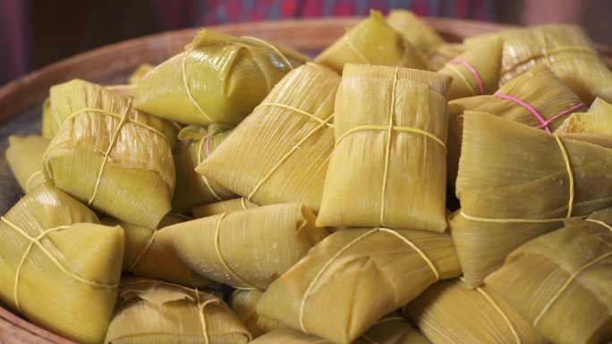 女人的手从锅里取出煮熟的Pamonhas，把它们放在筛子里。典型的巴西食物加绿玉米。主题视频的集合。