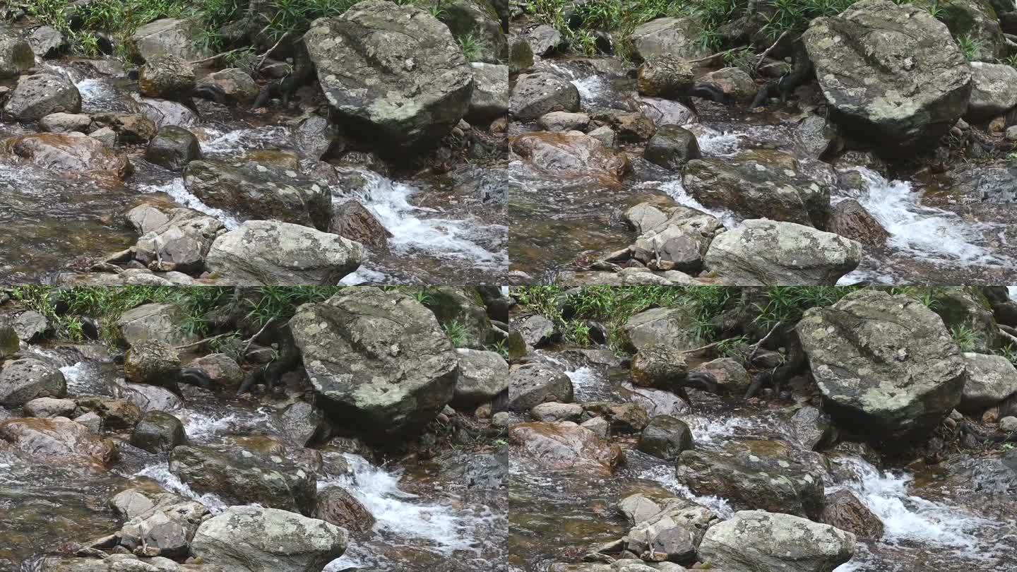 山涧间的岩石在峡谷中流淌，湍急的水流沸腾而起泡沫