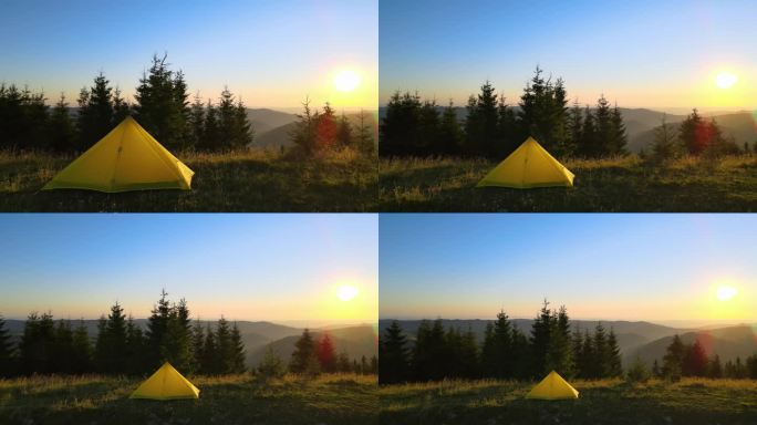 在明亮的日落时分，徒步旅行者在山坡上露营。阳光明媚的夜晚，山上露营地的帐篷。积极的旅游和徒步旅行理念