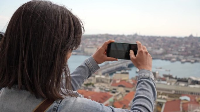 年轻女子在伊斯坦布尔的加拉塔桥拍照