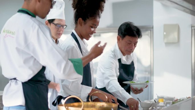 烹饪学生在烹饪学校向厨师学习