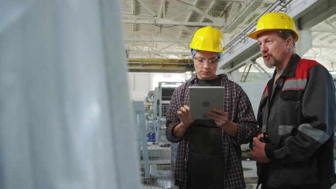 女工程师在石材厂用平板电脑与同事交谈
