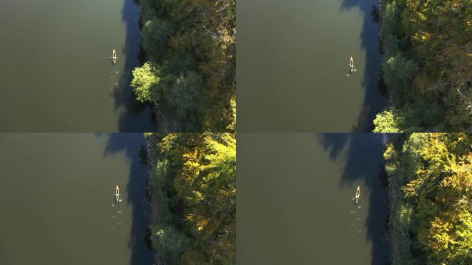 一个人在皮艇或皮艇上漂浮在靠近岸边的湖上