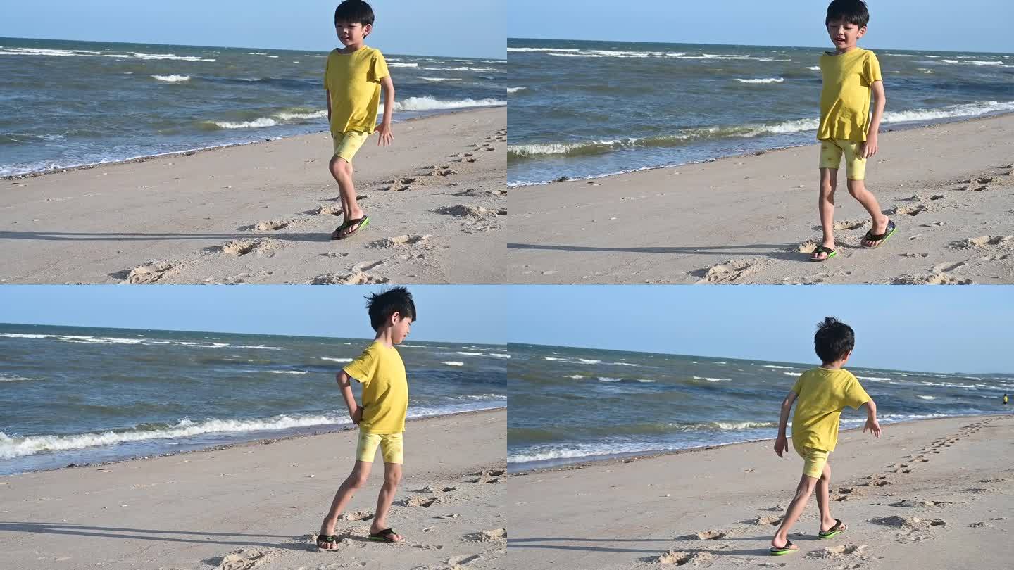 亚洲可爱的男孩在沙滩上玩沙子，慢动作的场景