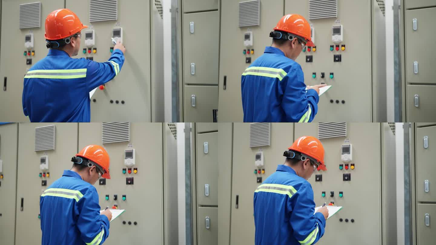 电气工程师在开关柜室的控制面板上检查电气系统。在剪贴板上做笔记。在受控环境中维护电气系统的完整性所涉