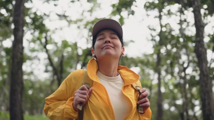 徒步旅行的女人呼吸清新的森林