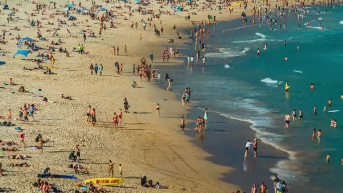 在澳大利亚新南威尔士州悉尼的夏季周末，人们在标志性的邦迪海滩享受阳光，放松身心