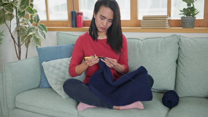 女人在沙发上织毛衣