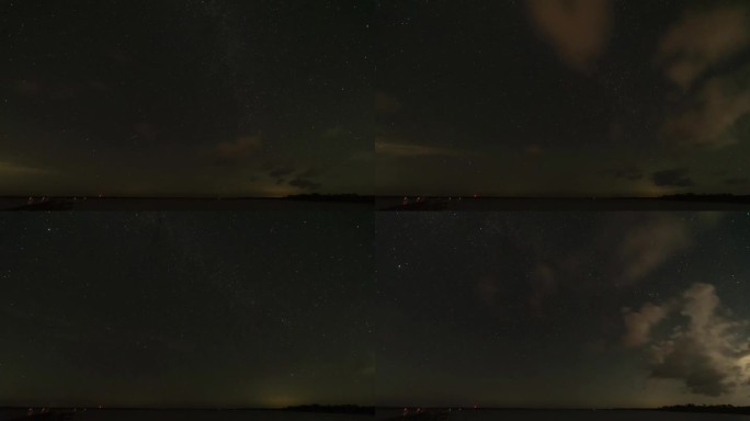海湾星空的夜间延时拍摄，左下方是码头，头顶上飘着小云