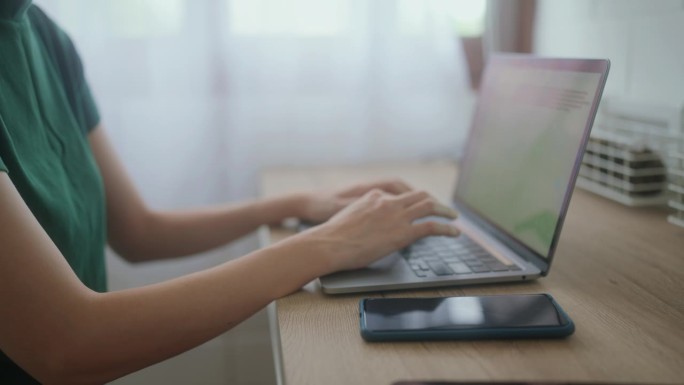 年轻女企业家在家用笔记本电脑工作，拥抱小企业自由。