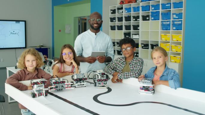 科技老师和学生手持电动机器人模型的画像