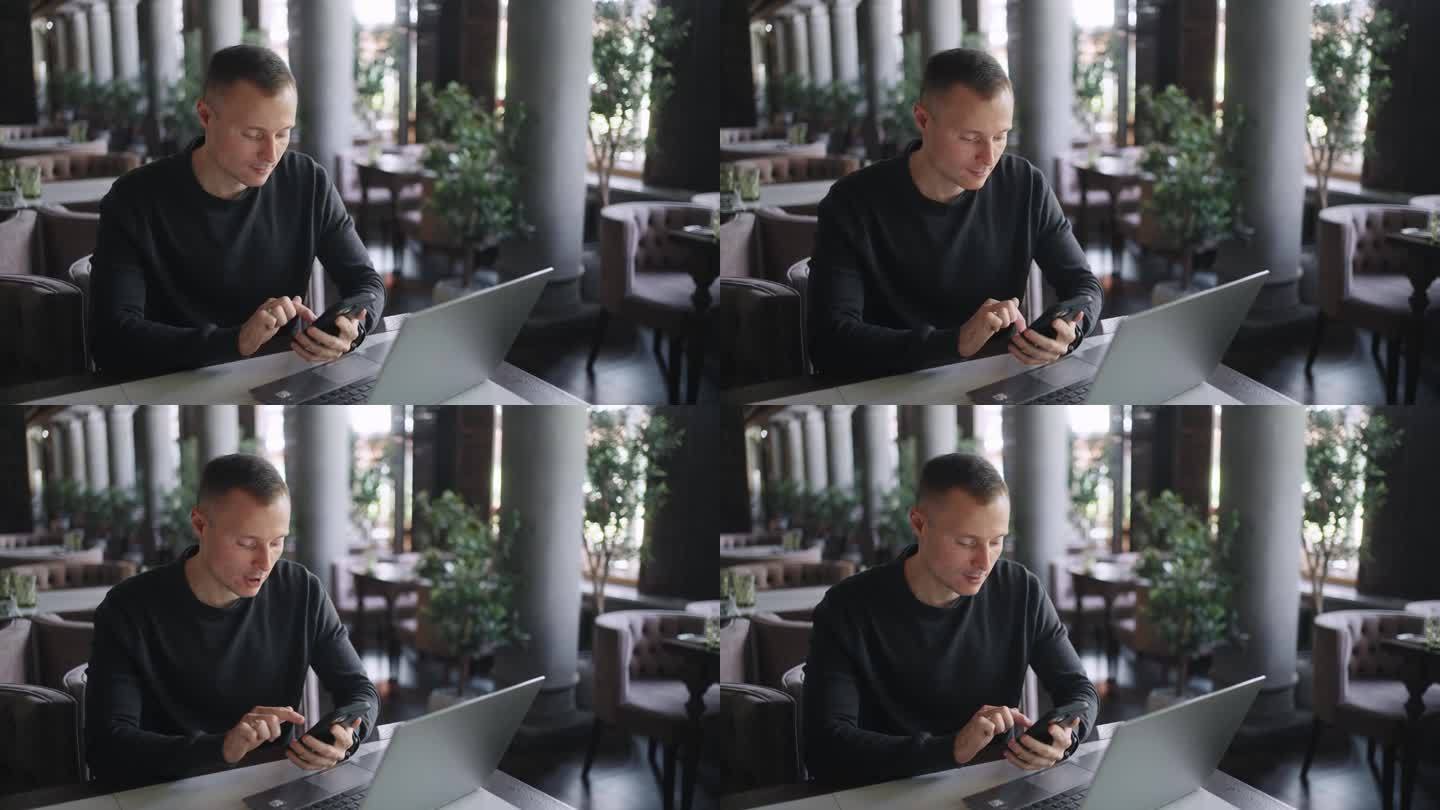 男性用户在咖啡馆用智能手机和笔记本电脑，自由职业者用手机上网