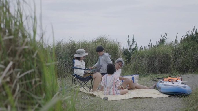 一个日本家庭在海滩上一起打视频电话