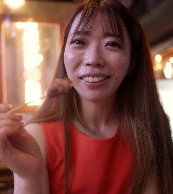 身穿橙色礼服的女商人在居酒屋酒吧直播，吃着日式烤鸡串(二集之一)