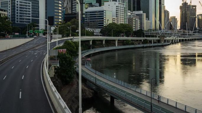 高速公路上的交通道路和现代办公大楼和布里斯班河旁的建筑工地，与Kurilpa，维多利亚和库克船长桥，