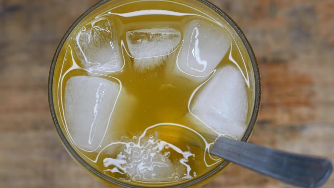 一杯起泡的凯匹林纳酒的特写镜头。凯匹林纳酒杯的配方:cachaa(甘蔗酒)、冰块、糖和百香果种子。桌