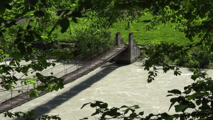 木长悬索桥横跨森林中的河流