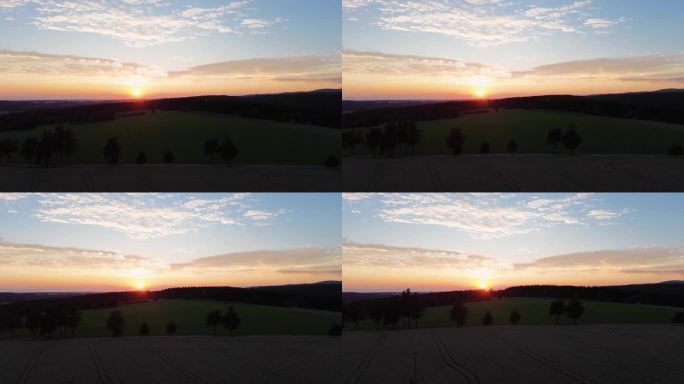 当相机慢慢下降到地面时，从山上的无人机上看到美丽的金色日落
